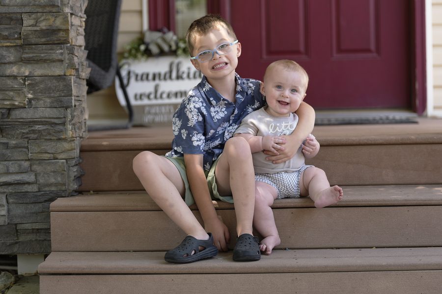 Two brothers hugging on their grandparents' porch steps